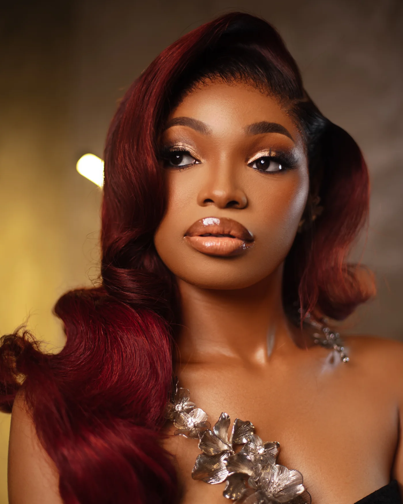 Glossy burgundy hair styled in side-swept waves by Unique Hair Affairs